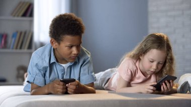 Afrikalı çocuk kız arkadaşı onun smartphone, kıskançlık tipik haber bakarak
