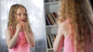 Sevimli kız boyama dudakları ile anneler ruj, Yetişkin kadın gibi davranmak