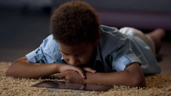 Einsamer Junge Sieht Tablet Film Hause Auf Dem Boden Liegend — Stockfoto