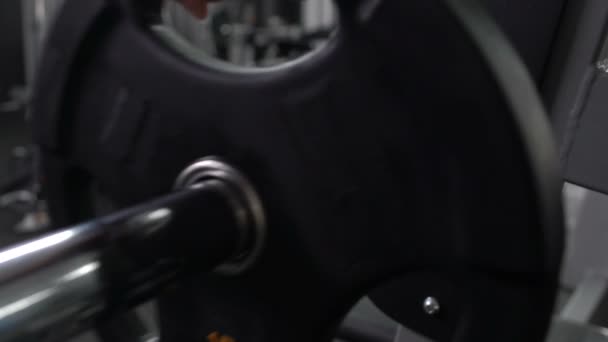 Deportista añadiendo placa de peso en la barra de gimnasio, gimnasio, ocio activo — Vídeos de Stock