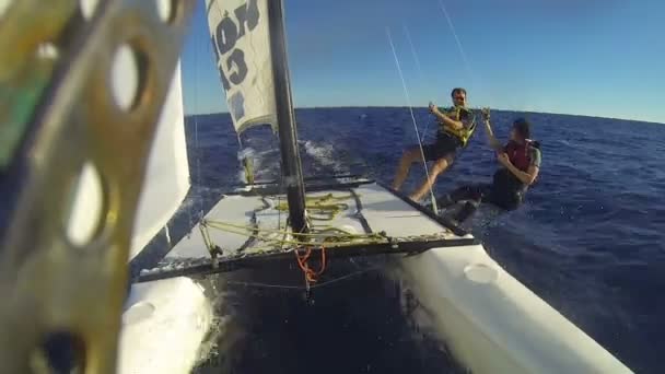 Katamaran under segla i hög hastighet, människor undan den hull hög fiving varandra — Stockvideo