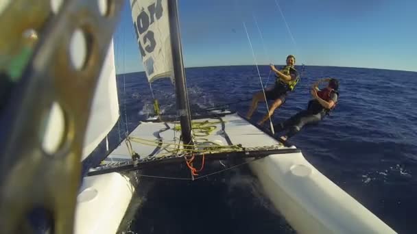 An Seilen befestigt Katamaran Windsurfer überhängenden Rumpf, winkt vorbeifahrenden Vogel — Stockvideo