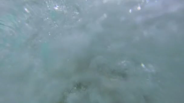 Парень держит подводную камеру и снимает людей, плавающих в бассейне — стоковое видео