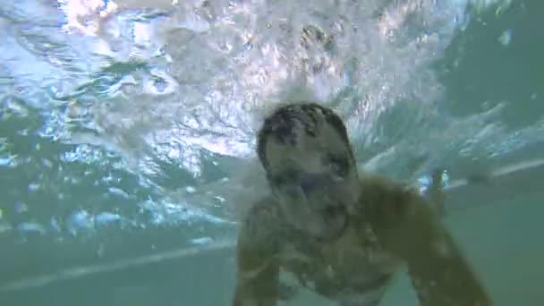 Cara pulando na piscina com câmera na vara na mão, se divertindo — Vídeo de Stock