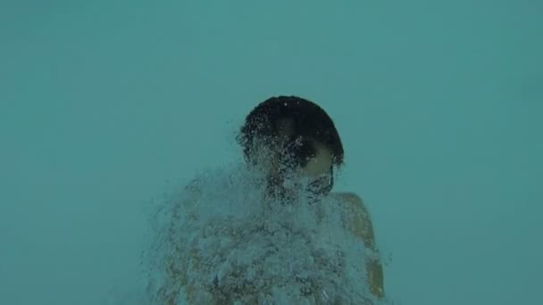 Homem caindo para trás na piscina, segurando a câmera em suas mãos, mergulhando e saindo — Vídeo de Stock