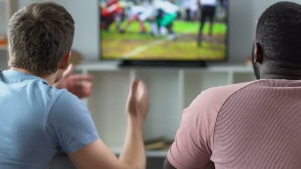 Fãs de futebol multirracial assistindo jogo na frente da TV, desapontados com o resultado — Vídeo de Stock