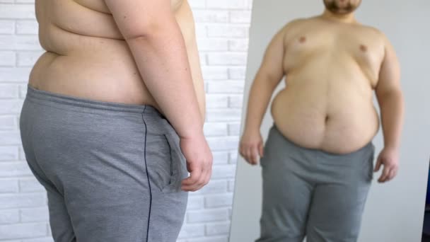 Zwaarlijvige man lijdt aan overgewicht van de buik, die in de spiegel, gezondheidsprobleem — Stockvideo