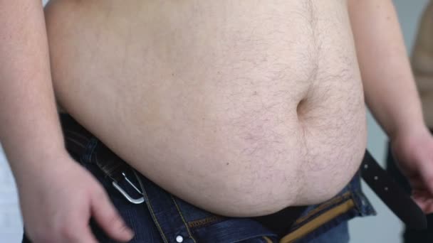 超重男子压缩牛仔裤, 患有胃脂肪, 荷尔蒙疾病 — 图库视频影像