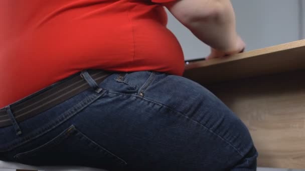 Fat man sitting on chair and working at laptop, lack of activity, lazy lifestyle — Stock Video