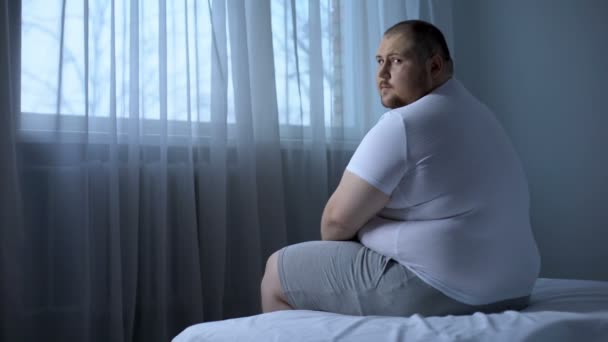 Trauriger schwerer Mann, der zu Hause im Bett sitzt, Gesundheitsprobleme, Depressionen, Unsicherheiten — Stockvideo
