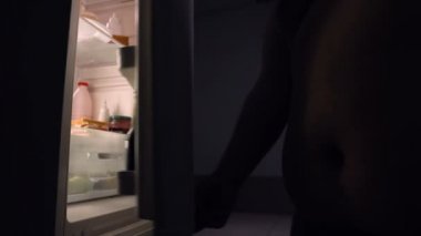 Şişko göbek adam alarak sandviç mutfak dolabı, geceleri, abur cubur yeme üzerinden