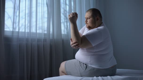 Uomo obeso che soffre di dolore al gomito, infiammazione delle articolazioni, centro di riabilitazione — Video Stock