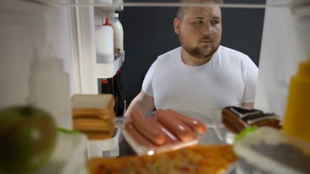 Fat male secretly taking beer bottle from fridge night, drinking with pleasure — Stock Video