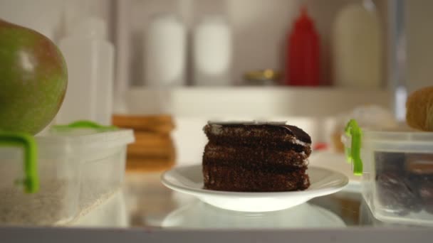 Übergroßer Mann, der nachts ein Stück Kuchen aus dem Kühlschrank nimmt, Diabetes-Risiko, Kalorien — Stockvideo