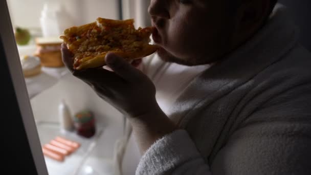 Unmotivated παχύσαρκα πτυχίο τρώγοντας πίτσα κοντά στο ψυγείο το βράδυ, διατροφή αποτυχία — Αρχείο Βίντεο