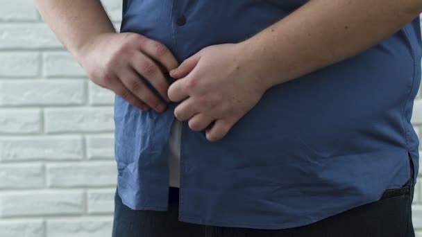 Homem gordo com dificuldade em abotoar camisa na barriga enorme, inseguranças plus-size — Vídeo de Stock