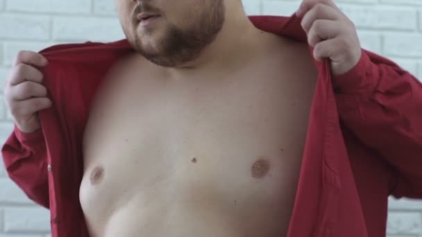 Obese man hardly wearing shirt on fat body, extra large size, slow-motion — Stock Video