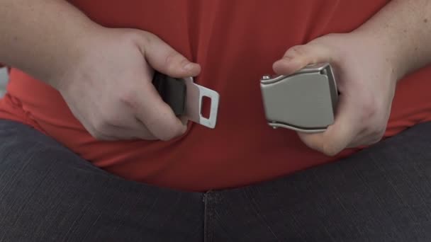 Overgewicht man probeert te fasten seat belts op enorme buik, comfort in vliegtuig — Stockvideo