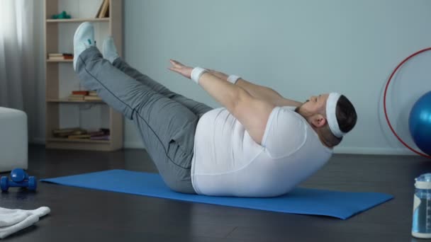 Hombre gordo practicando ejercicio estático abdominal, fuerza y desarrollo de resistencia — Vídeo de stock