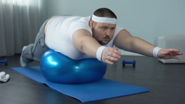 Obese hardworking man practicing static exercise, strength training program — Stock Video