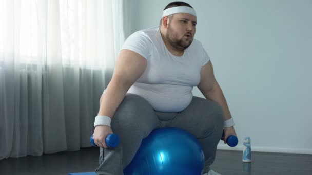 Gyenge túlsúlyos férfi küzd, hogy szüntesse meg a súlyzók, a fizikai aktivitás hiánya diéta — Stock videók