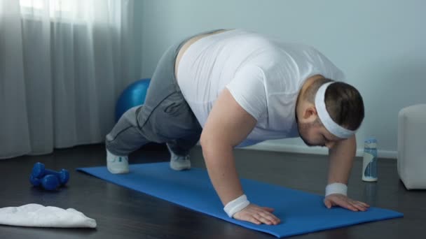 Fat Man probeert te opdrijven oefening thuis, zwakke spieren, gebrek aan motivatie — Stockvideo