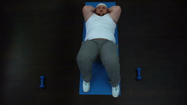 Karın Egzersizi ev, zor fitness programı, tembellik yapıyor yorgun obez erkek