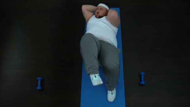 Szorgalmas kövér ember csavar felülés, kényszeríti magát, sport fegyelem — Stock videók