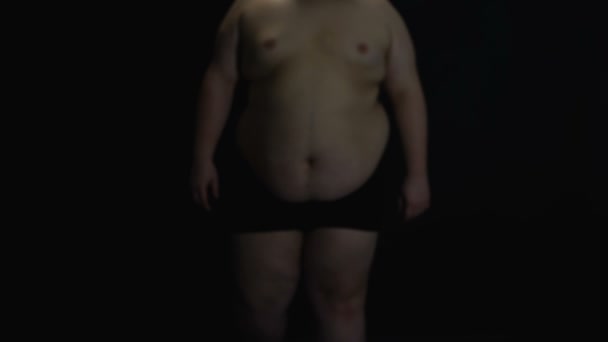 Παχύσαρκος άντρας σε μαύρο φόντο, υπέρβαρο πρόβλημα, υπερκατανάλωση τροφής, την υγειονομική περίθαλψη — Αρχείο Βίντεο