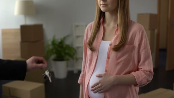 Laki-laki tangan agen memberikan kunci dari rumah untuk wanita hamil muda yang terjangkau perumahan — Stok Video