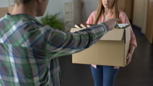 Злой мужчина расстается с девушкой, несчастная женщина покидает дом, вещи в коробке — стоковое видео