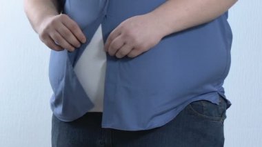 Ekstra büyük bez, vücut bakımı çalışırken kadar sıkı tişörtünü, düğmelerini genç obez erkek