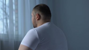 Obez erkek geri yapıyor oturma yatak, spor, eksikliği kas germe egzersizleri