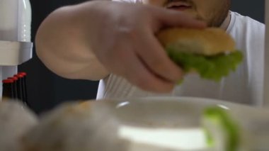 Hamburger önünde çiğneme abur cubur adam için buzdolabı, sağlıksız beslenme bağımlısı