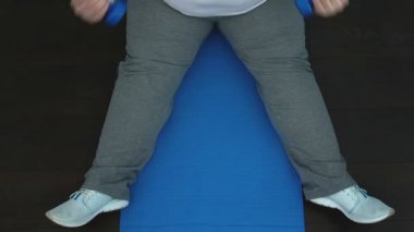 Yorgun obez erkek eğitim dumbbells ile en iyi görünüm, egzersiz sonuçlarını bekliyor