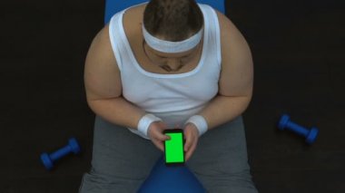 Fitness Rehberi egzersizleri Smartphone, spor blog izlerken şişman adam spor giyim