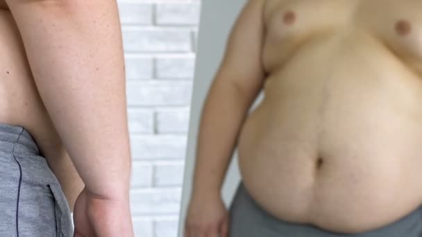 Boldogtalan túlsúlyos férfi nézett a kövér hasa, tükör, fogyás, bizonytalanság — Stock videók