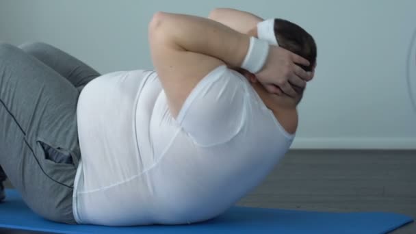 Hombre pesado motivado haciendo crujidos esfuerzo, calorías ardientes, ejercicios abdominales — Vídeos de Stock