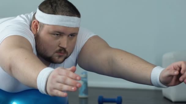 Elhízott ember, pihentető fitness labda komplex otthoni edzés után, a teljesítmény és a kitartás — Stock videók
