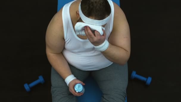 스포츠 운동 후 땀 수건 및 식용 수를 닦아 피곤된 뚱뚱한 남자 — 비디오