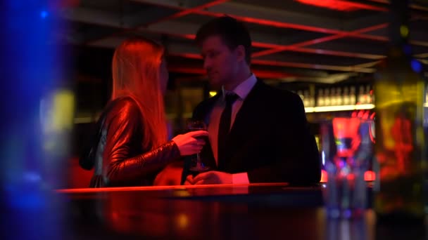 Женщина удивляет мужчину, общаясь в ночном клубе, знакомясь и флиртуя — стоковое видео