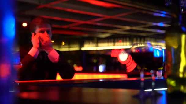 Ung man ringer taxi, sitter i bar ensam efterfesten, risken för rattfylleri — Stockvideo