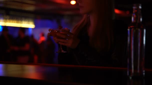 Elegantní žena pije koktejl v baru sama, poslech hudby, uvolněná atmosféra — Stock video