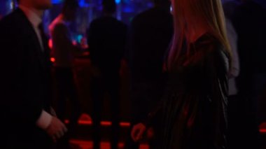 Güzel kadın, gece kulübü partide dans pistinde hareketli yürüme takım elbiseli adam