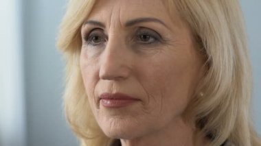 Kendine güvenen olgun kadın kendini gözlükteki aynaya bakmak koyarak prinking