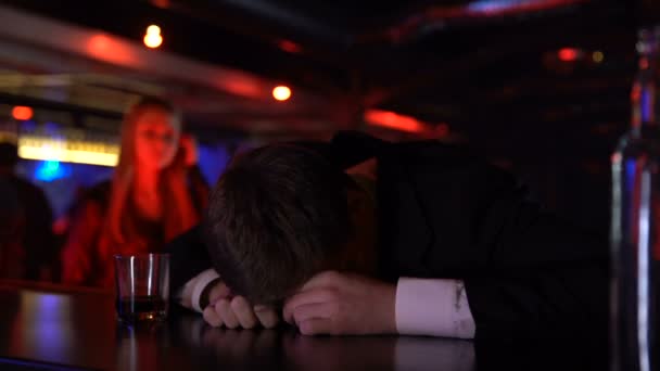 Ung kvinna hjälper berusad man att lämna bar, håller honom, alkohol missbruk koncept — Stockvideo