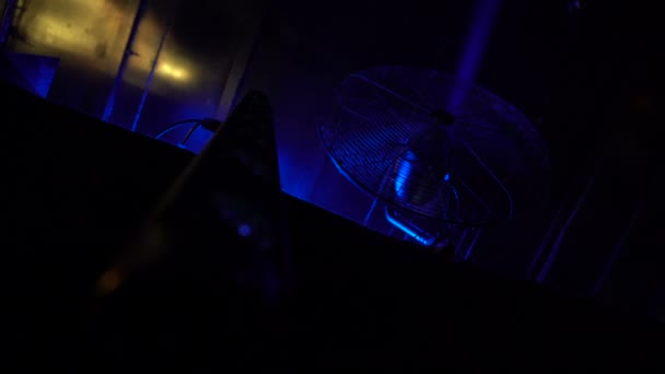 Rotující ventilátor a led světla pro osvětlení vybavení visí v temné noci klubu — Stock video