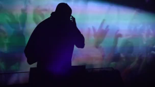 Silhouette eines professionellen DJs, der während des Auftritts mit Tontechnik arbeitet — Stockvideo