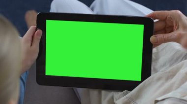 Torunu gösteren Büyükanne mobil apps yeşil ekran tablet, haberci