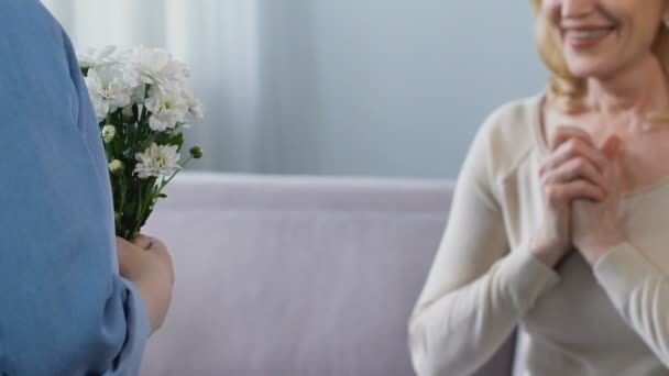 Lindo nieta dando abuela ramo de hermosas flores blancas, ternura — Vídeos de Stock